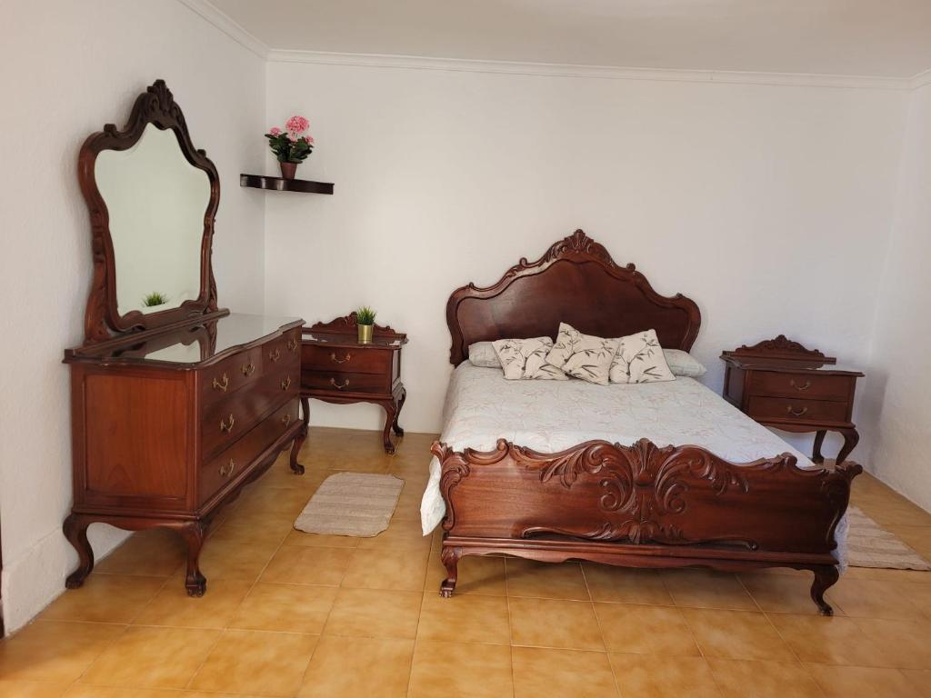 1 dormitorio con cama de madera, 2 vestidores y espejo en Castaño Bajo - Santa Brigida, en Santa Brígida