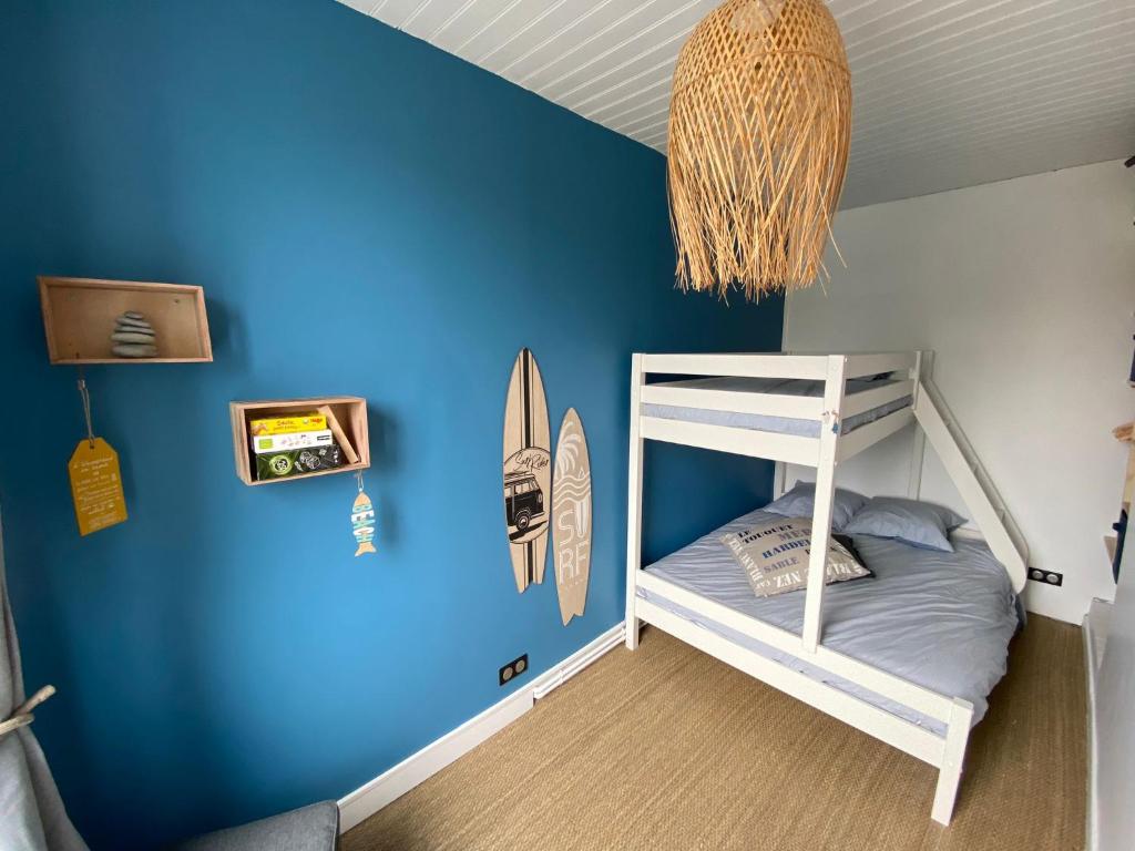 a room with a blue wall with a bunk bed at Rev d’Opale in Wimereux