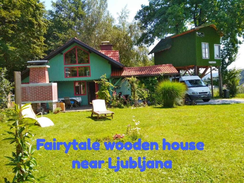 uma casa com uma casa verde e um quintal em Fairytale Wooden house by Ljubljana em Grosuplje