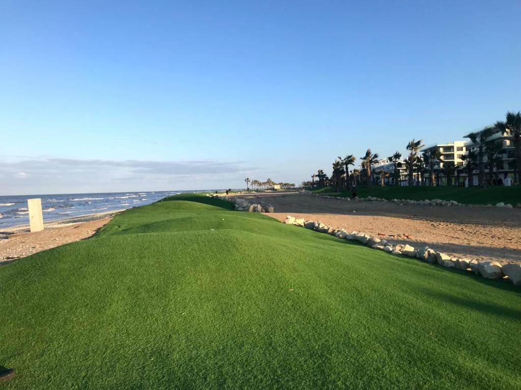 un campo de golf en la playa con el océano en el fondo en Porto Said Tourist Resort, en Puerto Saíd
