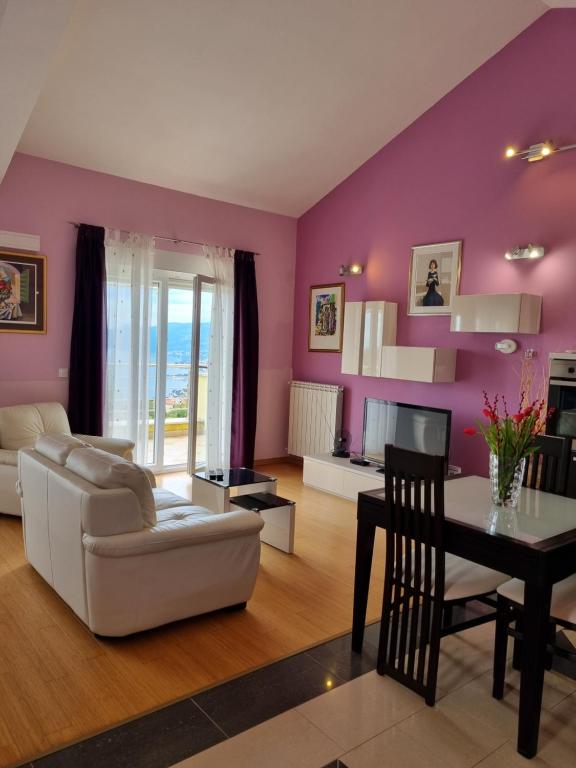 a living room with purple walls and a table at Kvarner Golden view Apartments in Matulji