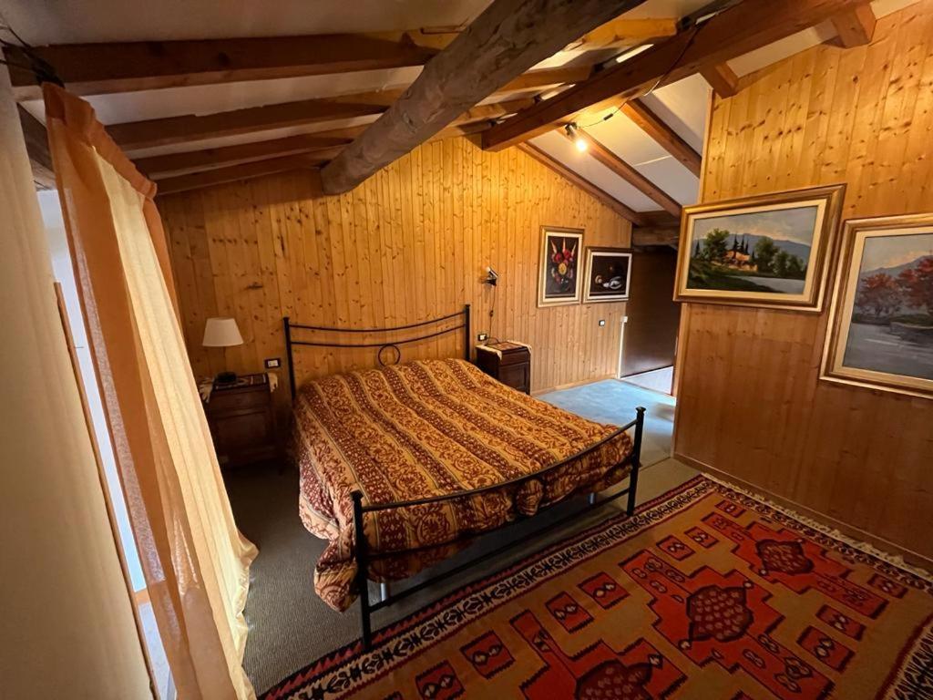 een slaapkamer met een bed in een kamer met houten wanden bij Cozy Castello in Manerba del Garda