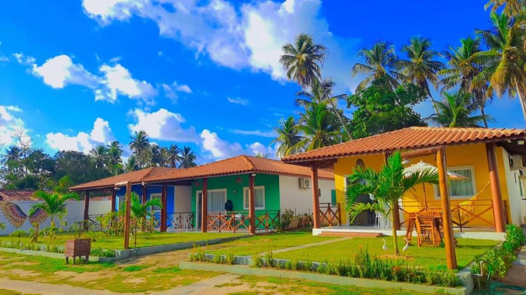 a house in the tropics with palm trees at Chalés Cantinho Da Mary in São Miguel dos Milagres