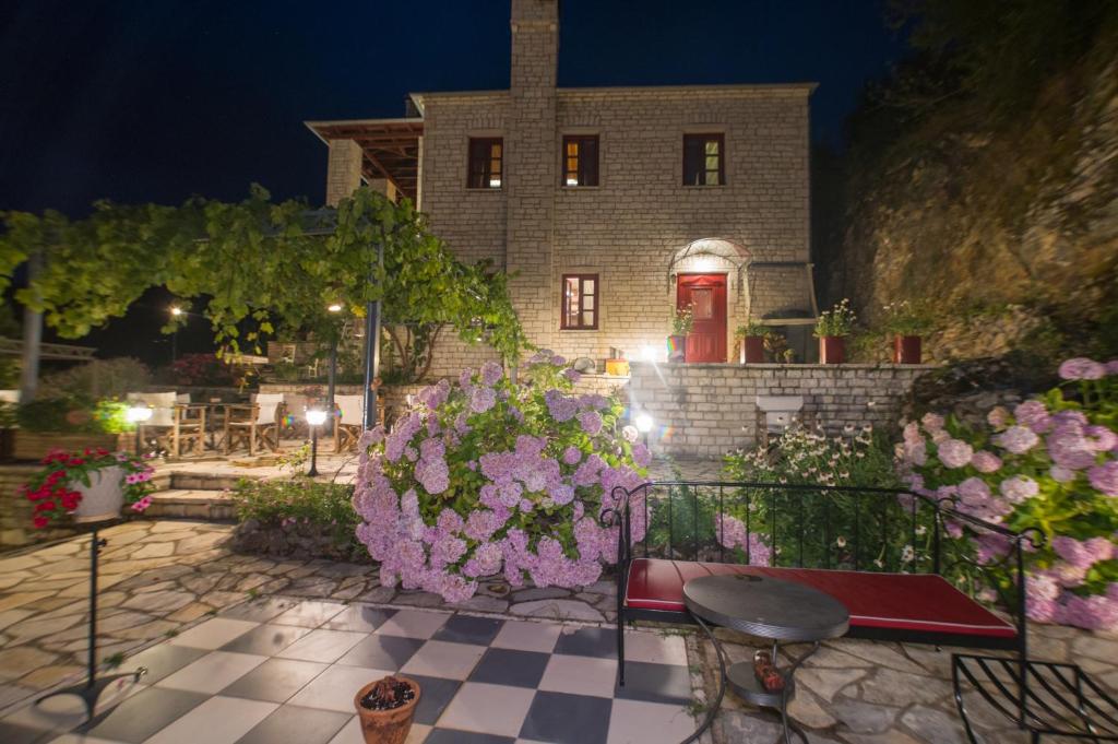 a house with a bunch of flowers in front of it at Meliteion Traditional Hotel in Asprangeloi