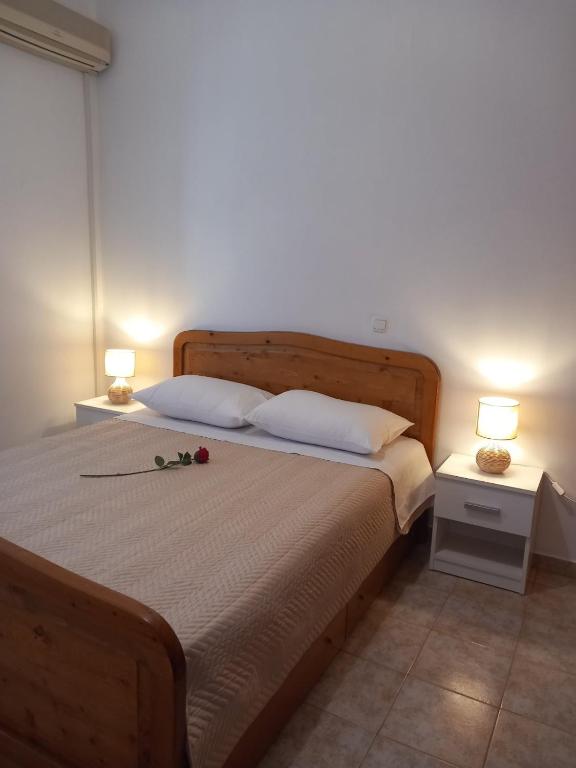 a bedroom with a bed with two lamps on it at Korali in Symi