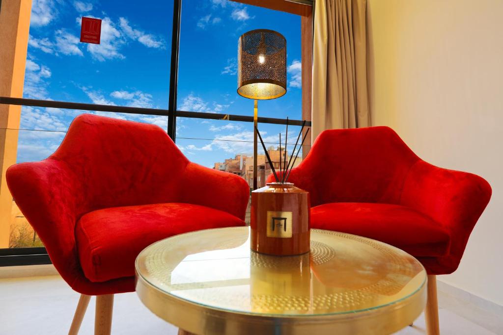 two red chairs and a table in front of a window at Ari Boutique Hôtel - Adult Only in Marrakech