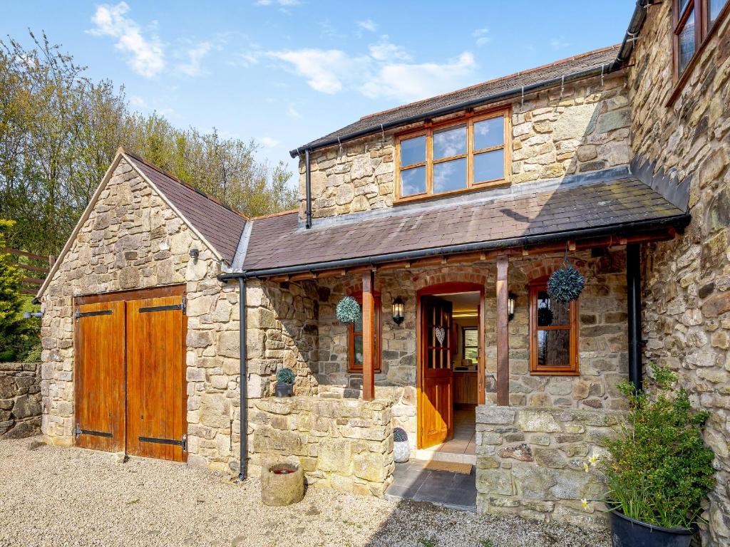 a stone house with a garage and a barn at Coed Y Gaer Annexe - Uk43776 in Llansilin