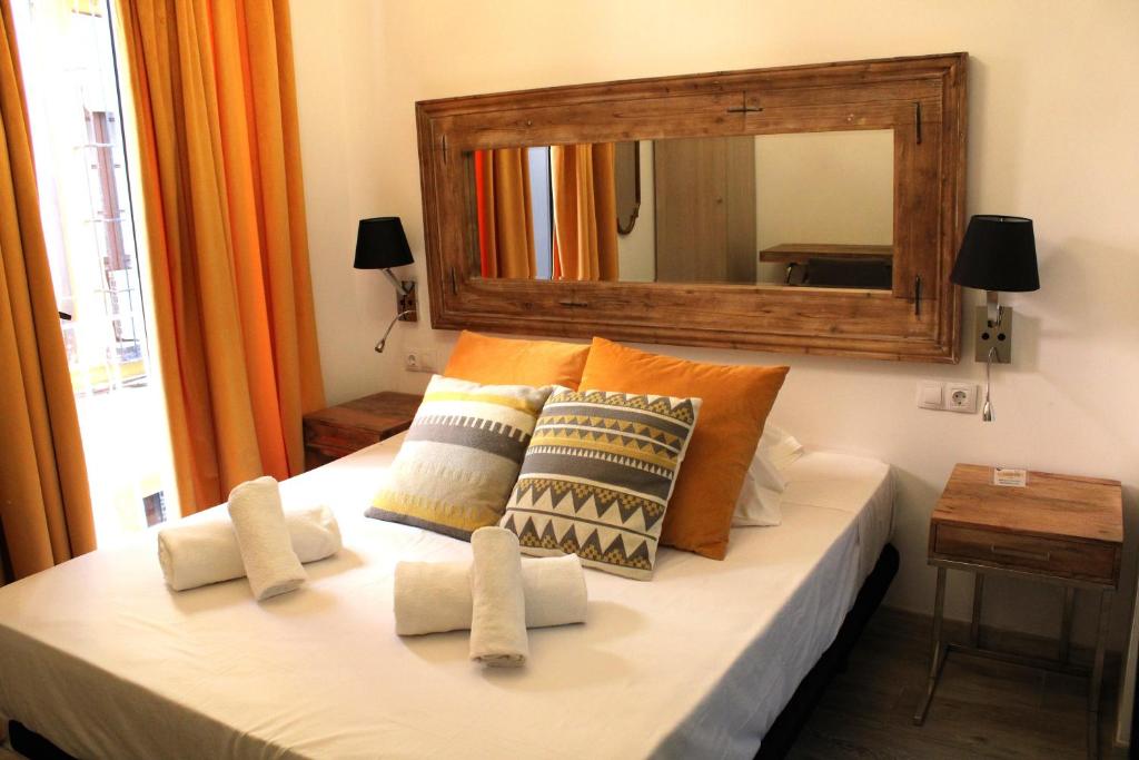 1 dormitorio con 1 cama con espejo grande en Doble S Rooms - Hostal en Sevilla