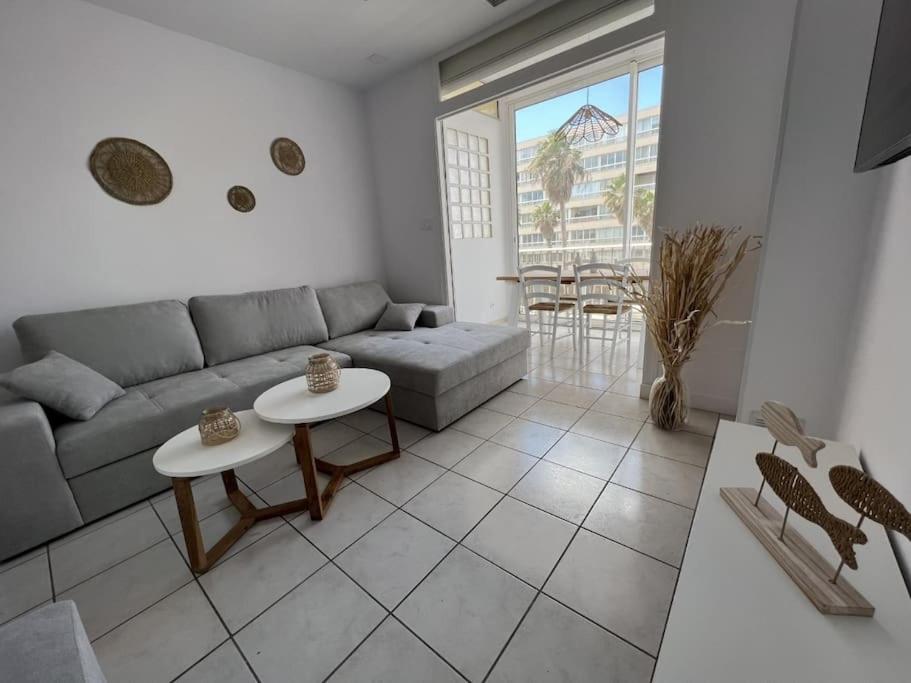a living room with a couch and a table at Superbe T2 vue mer, clim, parking gratuit in Canet-en-Roussillon