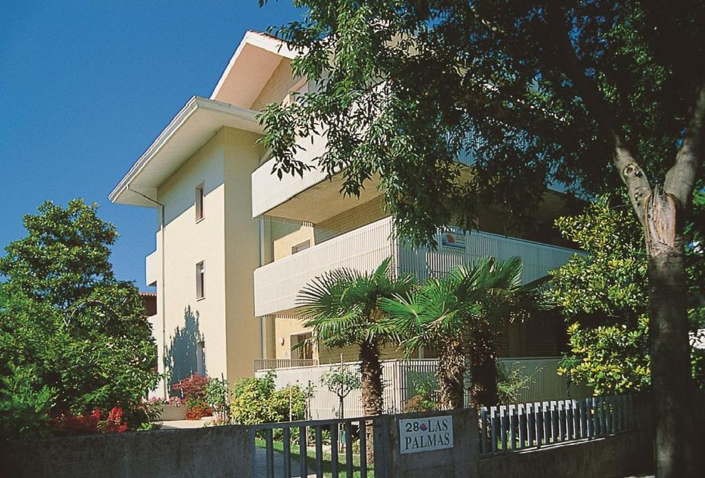 a building with a fence in front of it at Appartamenti Las Palmas in Lignano Sabbiadoro