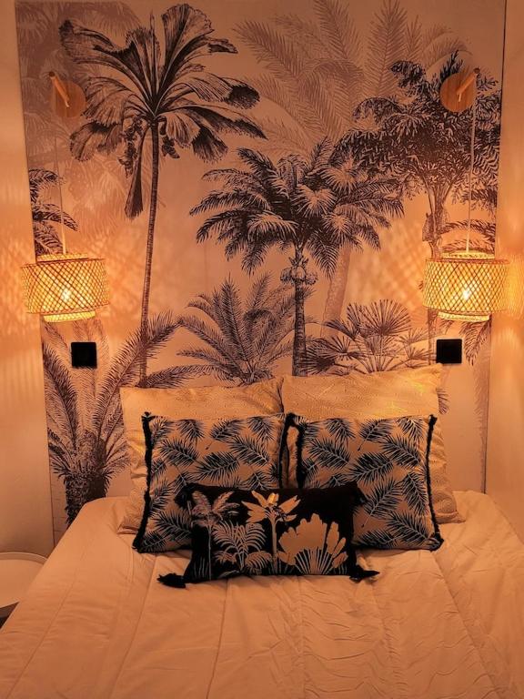 - une chambre avec un lit recouvert de palmiers dans l'établissement Vue mer et clim Les Restanques coquelicots 1115, à Grimaud