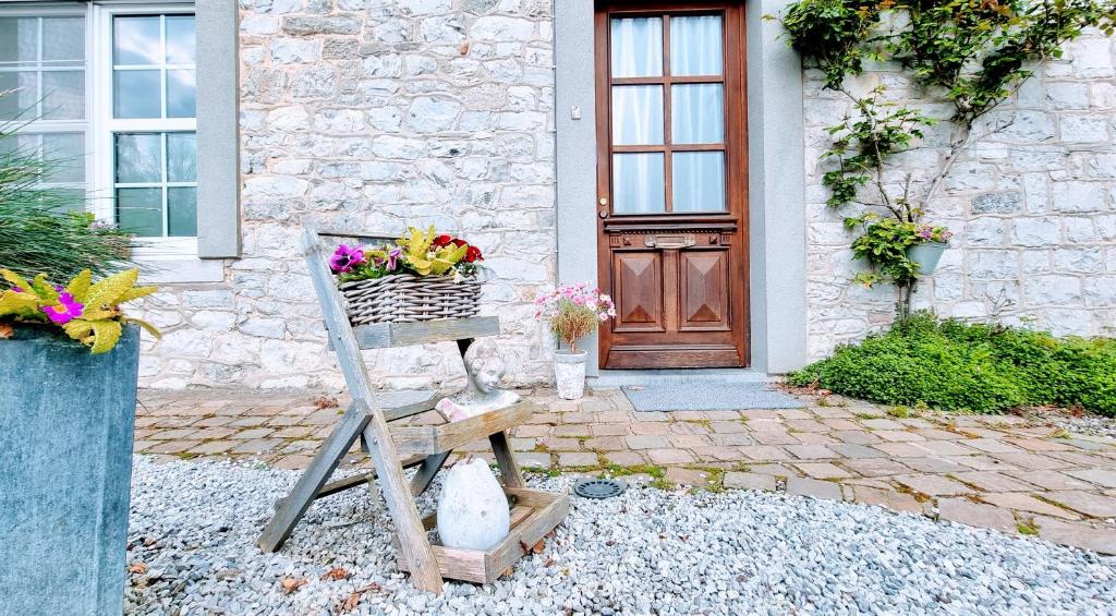 una cesta de flores sentada frente a una casa en Le Gîte de la Gray House en Mettet