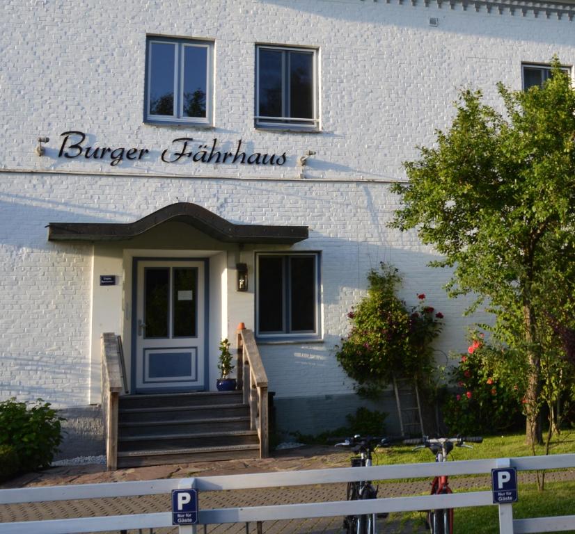 a white building with a sign that reads burger facilitinators at Burger Fährhaus in Burgerfeld