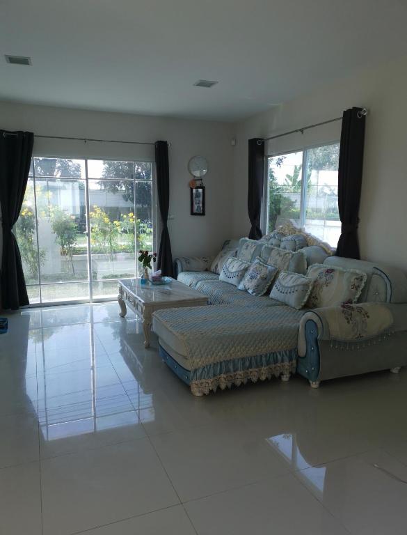 a living room with a couch and a coffee table at บ้านพักสุวรรณภูมิ​ แอร์​พอร์ต​ลิงค์​ลาดกระบัง in Ban Khlong Lat Bua Khao