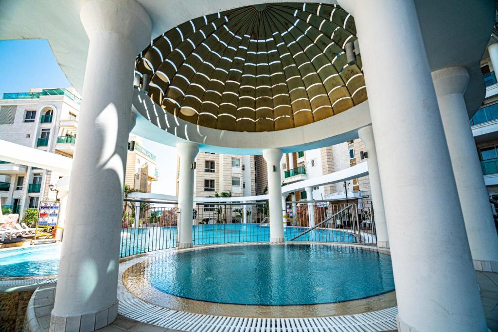 a building with a swimming pool in the middle at Golf Residence Sea and Soul in Eilat