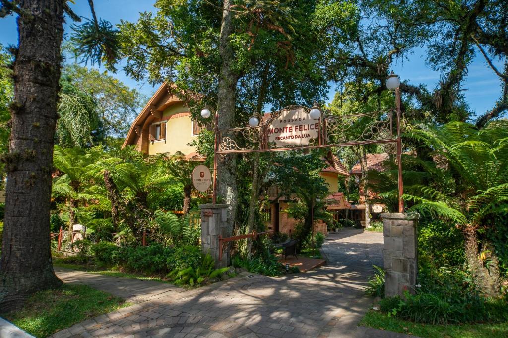 a gate to a house with a sign at Pousada Monte Felice Recanto da Lua in Gramado