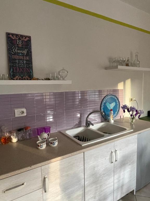 uma cozinha com um lavatório e um livro na parede em Panoramic View Apartment em Përmet