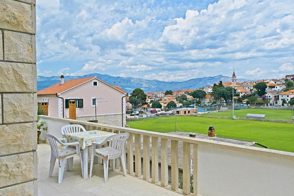 a balcony with a table and chairs and a view of a city at Apartment Toni with spacious terrace in Postira