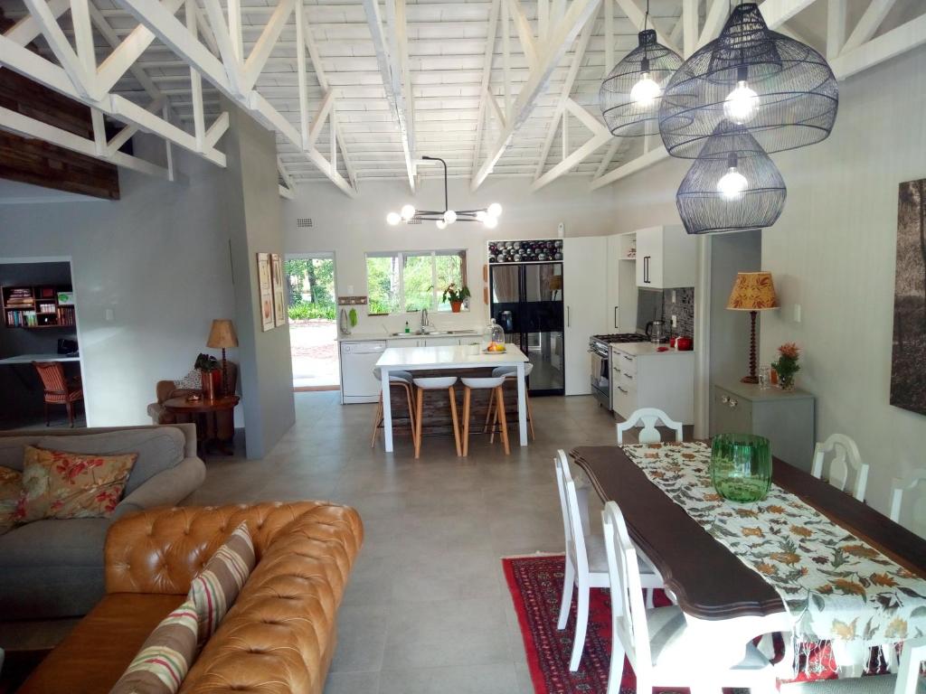 a living room and kitchen with a couch and a table at Farm House Plettneberg Bay in Plettenberg Bay