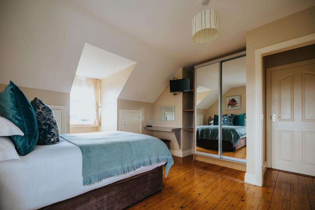 a bedroom with a large bed and a mirror at Móinéir House in Kilkee