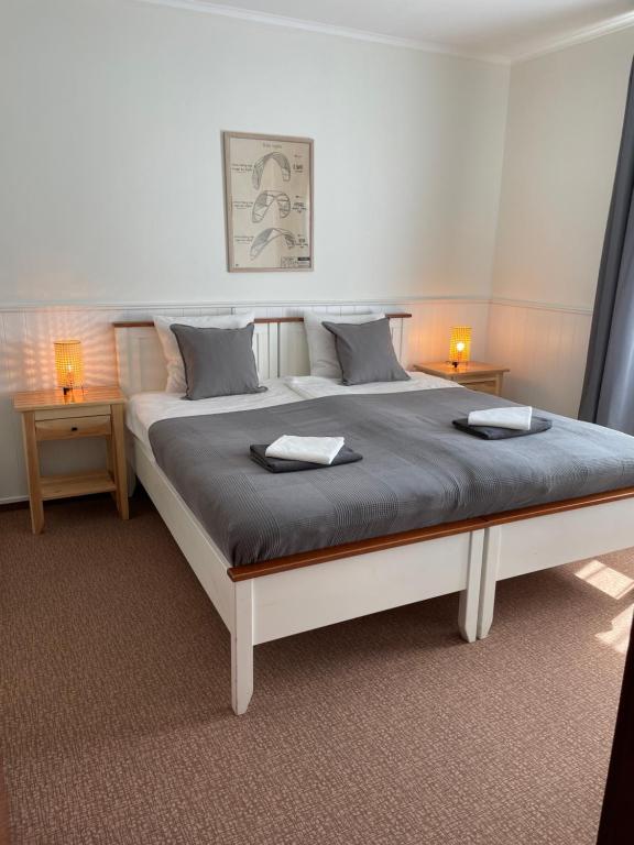 sypialnia z dużym łóżkiem z dwoma stołami w obiekcie Villa Baltic Apartament nr 3 w Chałupach