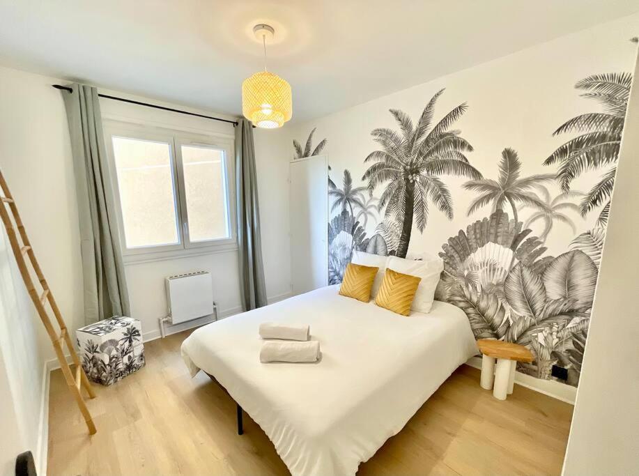 um quarto com uma cama grande com palmeiras na parede em La Douceur Roannaise - Parking privé proche gare em Roanne