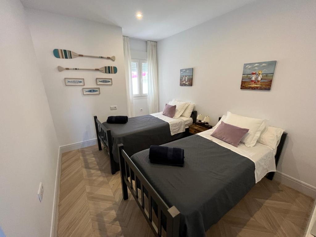 two beds in a small room with at Mirador de Sanlucar 9 in Sanlúcar de Barrameda