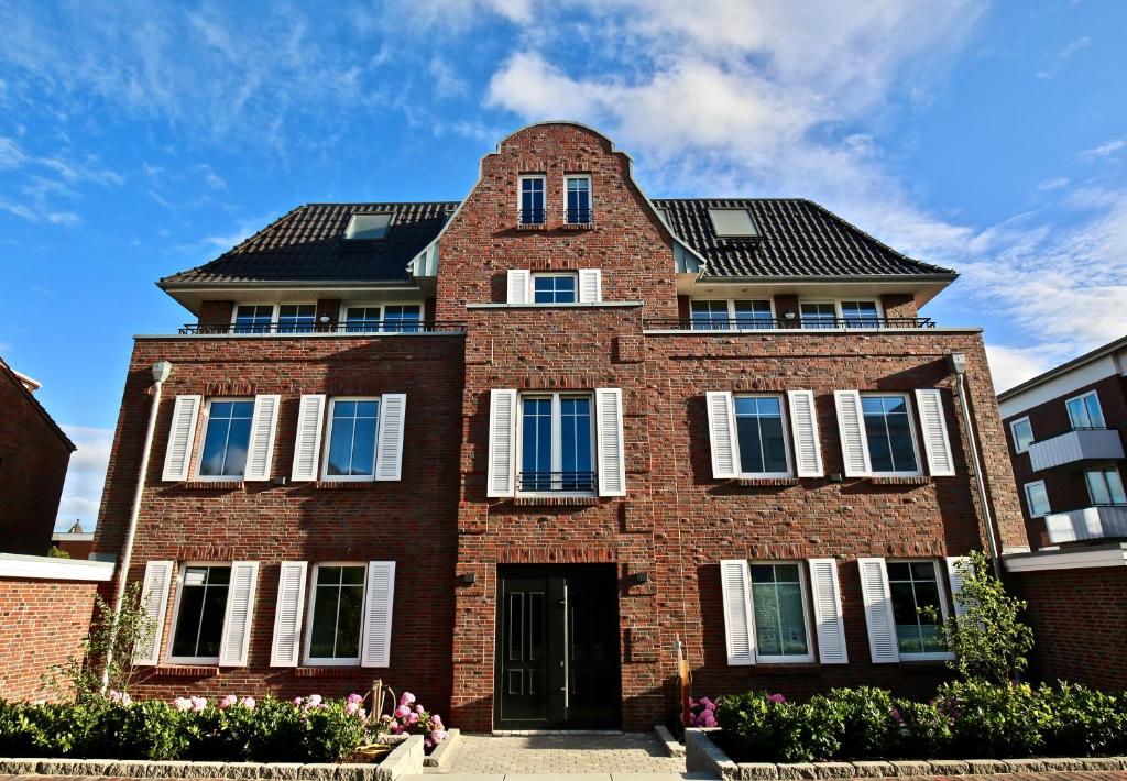 a red brick building with a black roof at Villa Petersen Ankerplatz 3 in Wangerooge