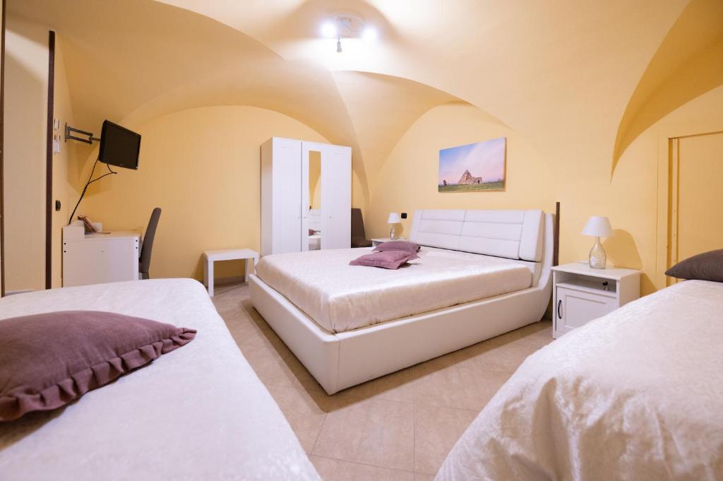 チステルニーノにあるLa casa di Aliceのベッドルーム(ベッド2台、テレビ付)