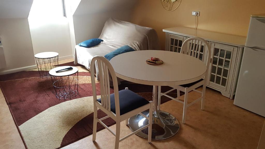 sala de estar con mesa y sofá en hebergement-luxeuil-les-bains, en Luxeuil-les-Bains