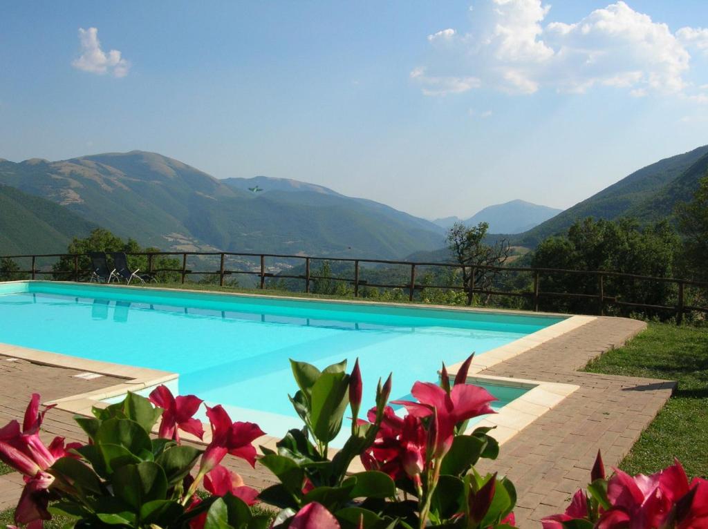 une piscine avec des montagnes en arrière-plan dans l'établissement Agriturismo Roccagelli, à Vallo di Nera