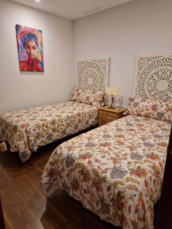 Casa Javier في سانت ماتيو: غرفة نوم بسريرين ولوحة على الحائط