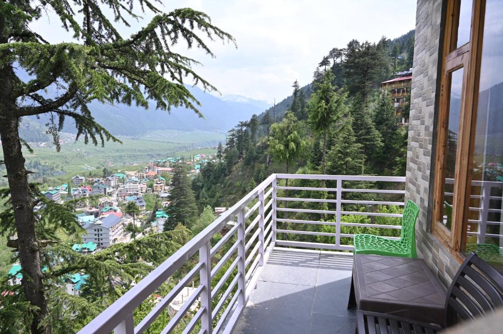 a balcony with two chairs and a view of a city at Hotel Seven Hills Manali in Manāli
