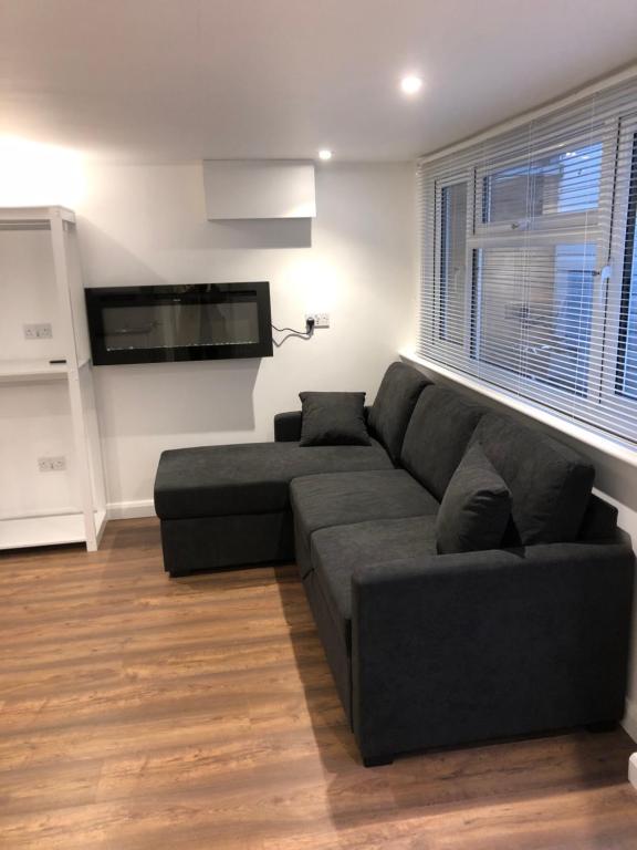 a living room with a couch and a flat screen tv at The Annexe Bedford in Bedford