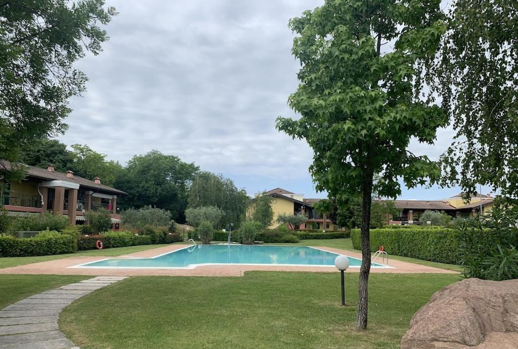 basen w ogrodzie obok domu w obiekcie Apartment in residence with swimming pool near Peschiera del Garda. w mieście Ponti Sul Mincio