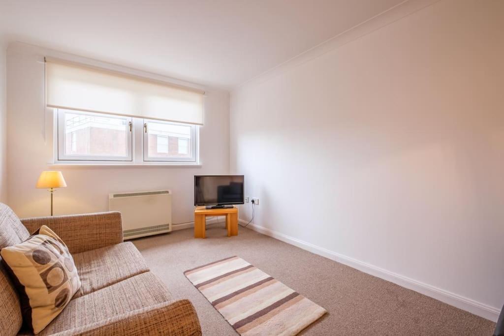 sala de estar con sofá y TV de pantalla plana en Station Apartment 1 bed- Lanark en Lanark