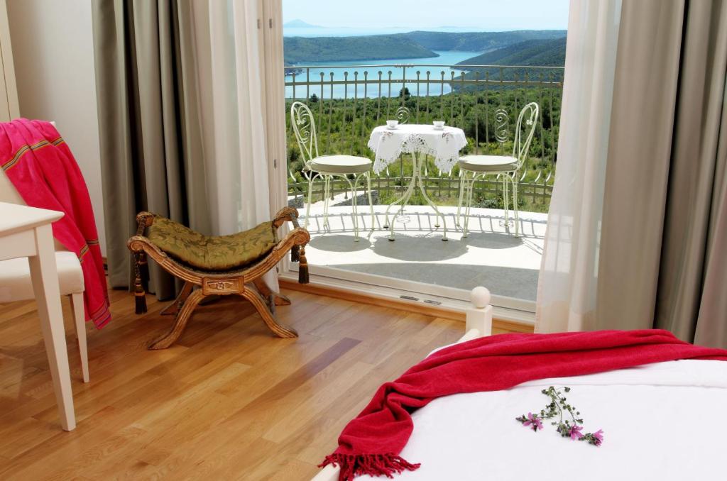 - une chambre avec un balcon doté d'une table et de chaises dans l'établissement VILLA STEFANIJA small Boutique hotel&restaurant, à Barban