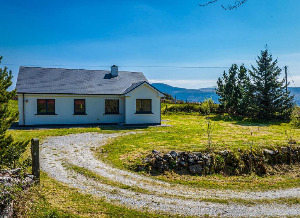 a house on a hill with a gravel road at Lakeview Waterville Holiday Home in Waterville