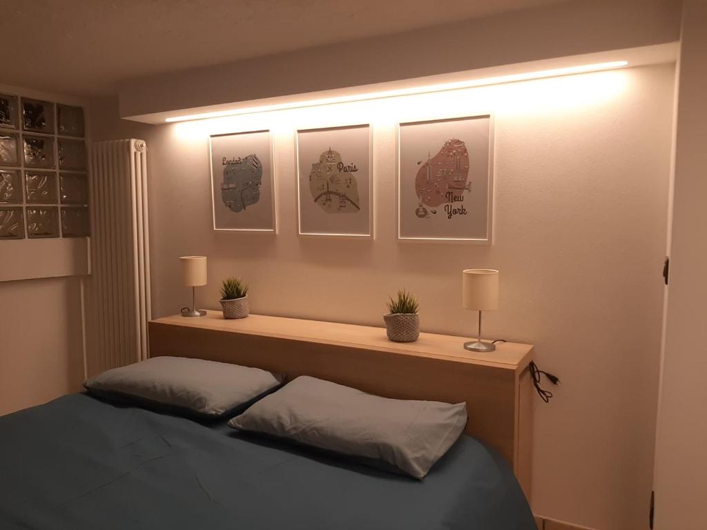 Karibu b&b في إيمولا: غرفة نوم بسرير بثلاث صور على الحائط