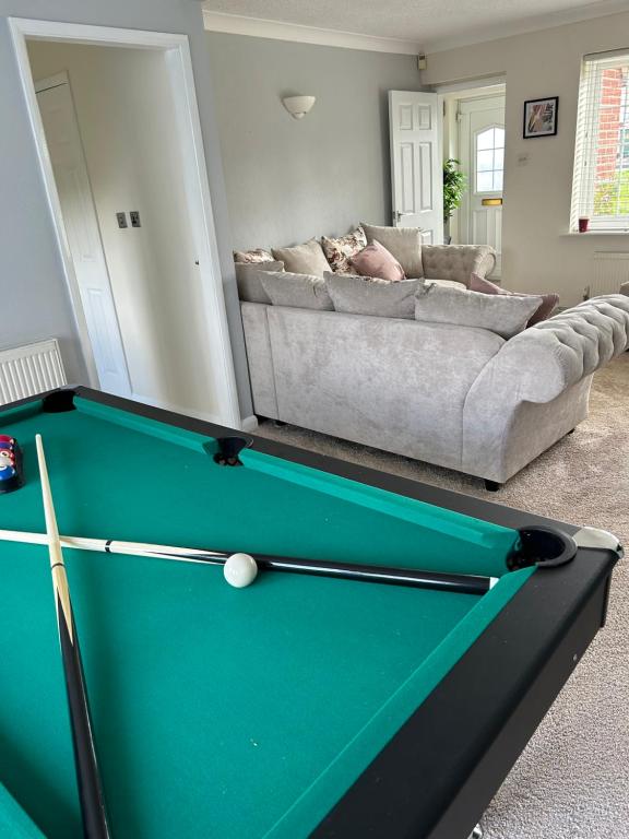 a living room with a pool table and a couch at 4 Bedroom House EMA with Parking and Garage in Castle Donington