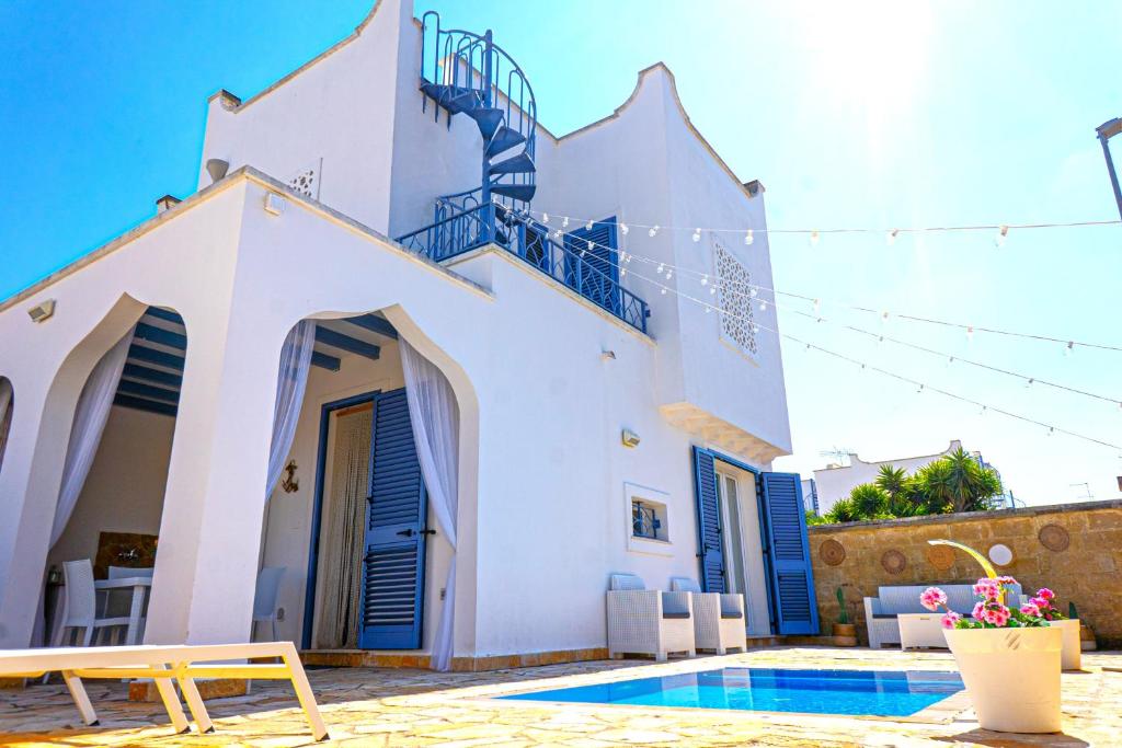 une villa avec une piscine et une maison dans l'établissement Villa Teresa, à Torre Lapillo