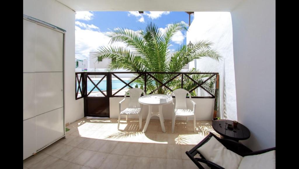 a patio with a table and chairs on a balcony at OasisstudioLanzarote in Puerto del Carmen
