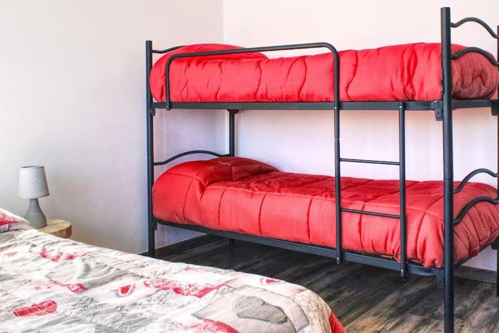 a bedroom with two bunk beds with red sheets at B&b da Teresa in Castelsaraceno