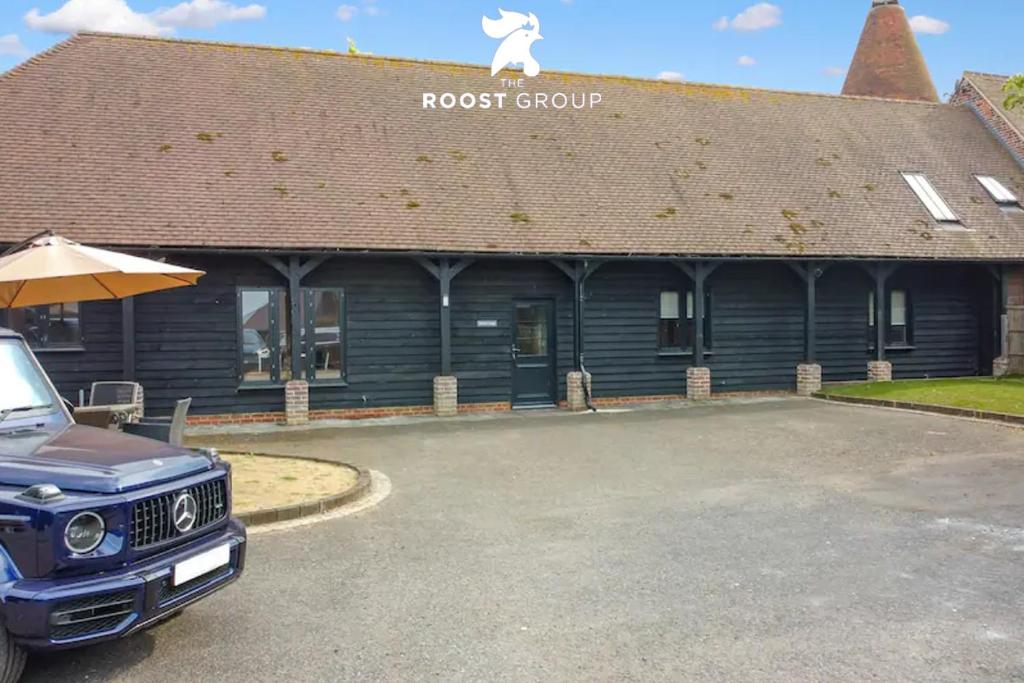 ein LKW, der vor einem Gebäude der Roost Group parkt in der Unterkunft The Roost Group - Meadow Lodge - Hot Tub in Kent