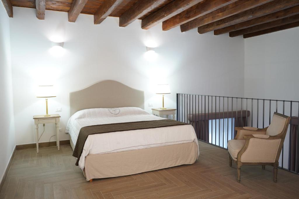 1 dormitorio con 1 cama grande y 2 sillas en Suite il ritrovo dei poeti, en Taranto