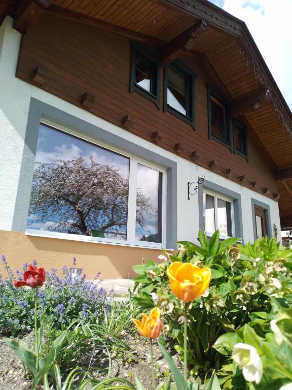 uma casa com uma janela com flores em frente em Ferienhaus Herrenschmiede em Obervellach