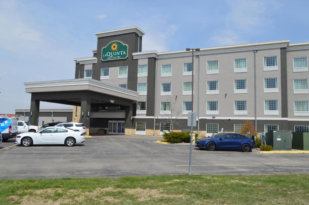 a large building with cars parked in a parking lot at La Quinta by Wyndham Rochester Mayo Clinic Area South in Rochester