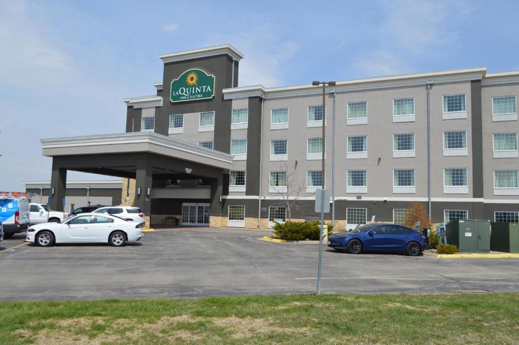 un gran edificio con coches estacionados en un estacionamiento en La Quinta by Wyndham Rochester Mayo Clinic Area South en Rochester