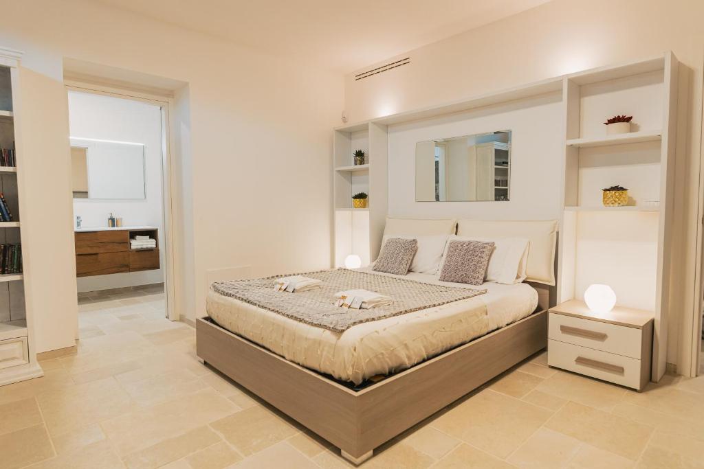 ein Schlafzimmer mit einem großen Bett und einem Spiegel in der Unterkunft Shangri-La Polignano a Mare in Polignano a Mare