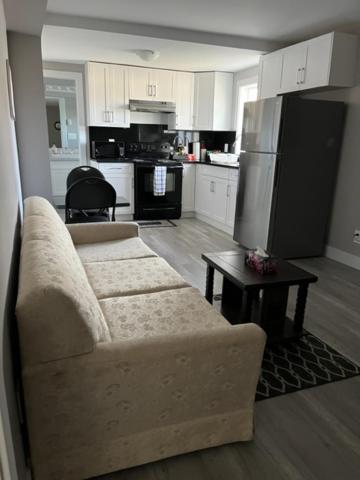 a living room with a couch and a kitchen at Brand new, One bedroom, two bed separated suite. in Victoria